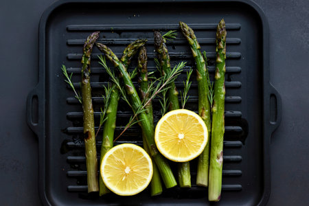Asparagus grill with lemon in black tray top viewの写真素材