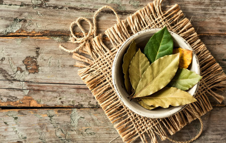 The bay leaves in ceramic bowl on shabby wooden background with copy spaceの写真素材