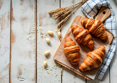 top view of croissants on cutting board on wooden background with copy spaceの写真素材