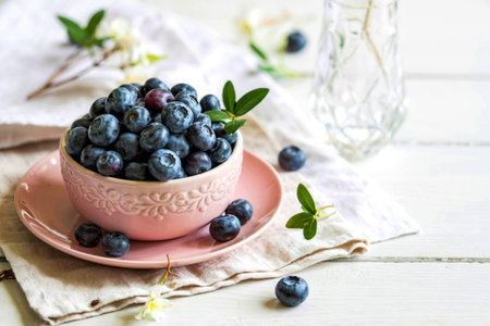 Ripe blueberry in a pink ceramic plate on a white table, tasty and useful berry, copy spaceの写真素材