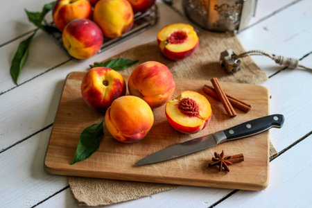 top view of fresh peach on a wooden kitchen board with knife with cinnamon sticks with fruitの写真素材