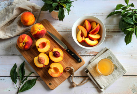 top view of fresh yellow peaches on a wooden kitchen board with knifeの写真素材