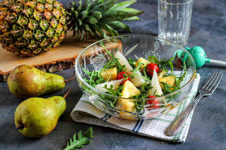 Salad with pineapple, pears and arugula in glass bowl. French gourmet foodの写真素材