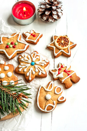 Christmas Gingerbread Cookies with Ornaments and Candle on Wooden Board