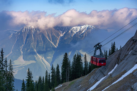 Red cable car ascending mountainous landscapeの写真素材