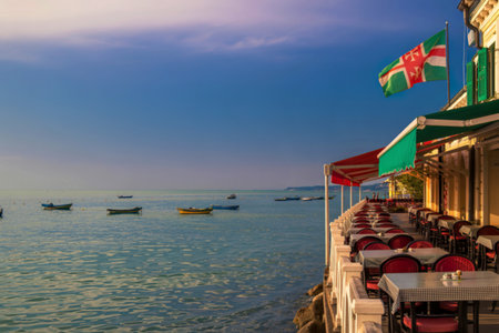 Mediterranean seaside restaurant with boats and flagの写真素材