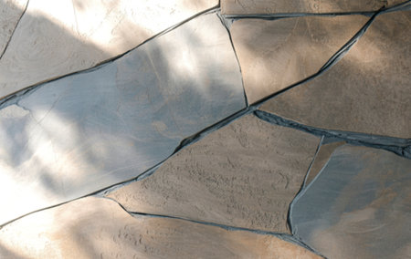 A close-up shot reveals a textured stone wall composed of irregularly shaped, light and dark brown...