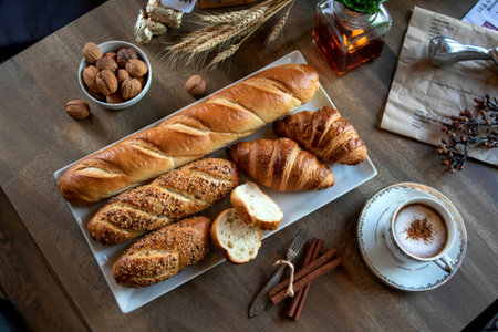 top view of breads as sliced seeded brown cob baguette and croissants in plate