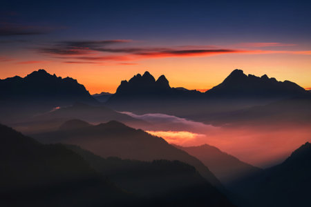 Majestic mountain range at sunrise with fog