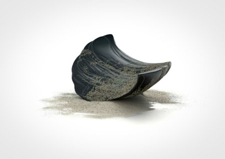 A dark, curved object with a textured surface is resting on a white background, partially covered in...