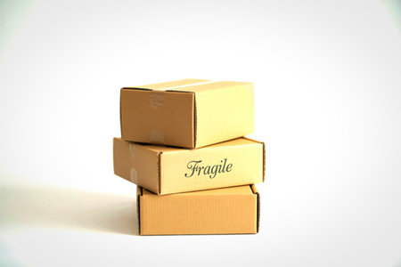 A stack of three small, plain cardboard boxes against a white background.の写真素材