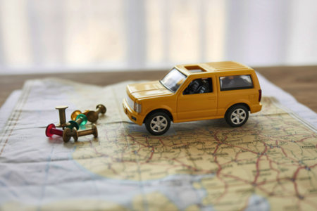 A small yellow toy car and a miniature luggage set are placed on a map, evoking a sense of journey...