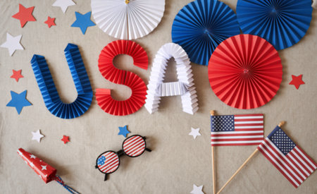 A vibrant arrangement of red white and blue decorations including USA letters fans stars and American flags for a patriotic holiday.の写真素材