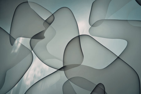 An abstract image featuring gray shapes with smooth curves and a soft blue background, creating a sense of depth and fluidity.の写真素材