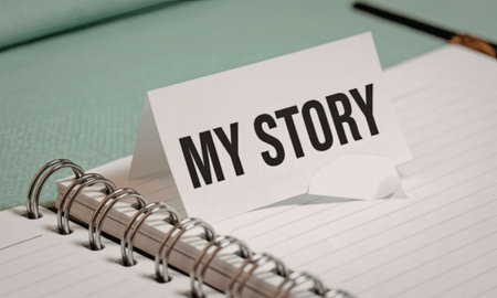 A spiral-bound notebook with a card that reads 'My Story' placed on top, accompanied by a pen on a green surface.の写真素材