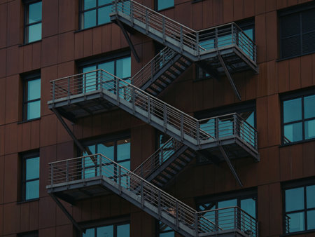 A close-up view of a fire escape staircase on the side of a building with multiple landings and railings.の写真素材