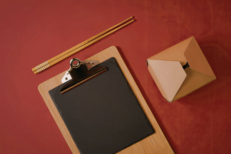 A clipboard with a black sheet of paper on a red backgroundの写真素材