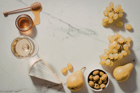 An arrangement of fresh fruits, honey, and olive oil on a marble countertop.の写真素材
