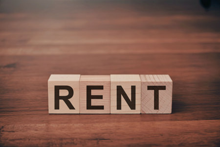 A close-up of wooden blocks arranged to spell 'RENT' on a wooden surface.の写真素材