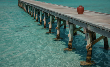 A serene and peaceful scene of a long wooden pier extending over the calm seaの写真素材