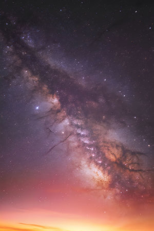 The Milky Way galaxy is visible in the night sky during sunset, showcasing its vibrant colors and...