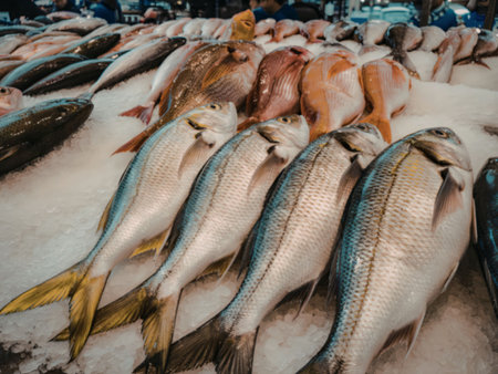 A variety of fresh fish are displayed on ice, showcasing their vibrant colors and textures.