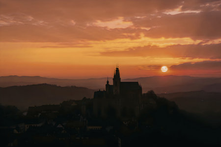 A breathtaking sunset over a castle's silhouette, with vibrant orange hues and a serene landscape.
