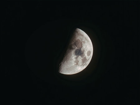 A close-up view of the moon in its crescent phase, showcasing its cratered surface against a black...