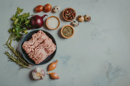 Raw ground meat on a plate surrounded by fresh herbs, spices, and vegetables on a marble surface.の写真素材