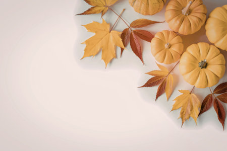 An image of small pumpkins surrounded by colorful fall leaves on a white background.