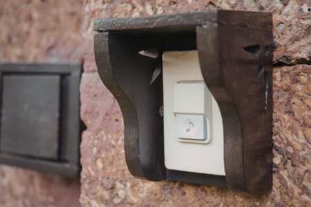 A close-up view of a light switch plate cover made of metal, mounted on a brick wall with a white light switch underneath.