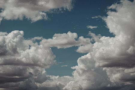 A serene image of a blue sky filled with numerous white, fluffy clouds.