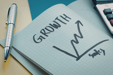 A close-up of a notebook page with a hand-drawn growth graph and the word 'GROWTH' written on it, accompanied by a pen and a calculator.
