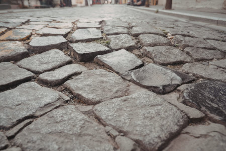 The image shows a close-up view of a weathered cobblestone street with uneven and cracked stones