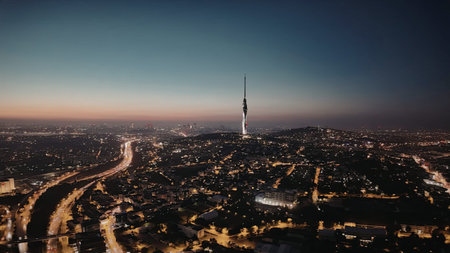 A cityscape at dusk with a prominent tower standing tall amidst the urban landscape.