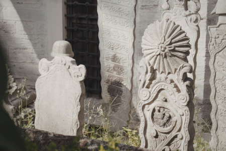 A close-up view of intricately carved stone monuments in a cemetery, showcasing detailed designs and weathered textures.