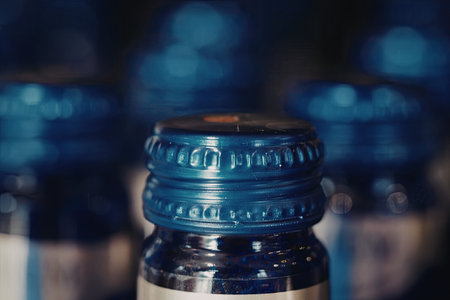 A close-up view of a blue bottle cap with other similar caps in the background