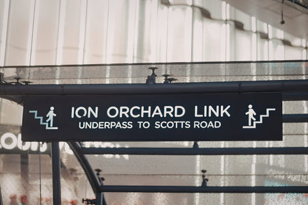 A black sign with white text and icons indicating the Ion Orchard Link underpass to Scotts Road.