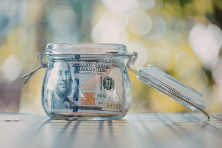 A glass jar filled with cash and currency, representing savings and financial planning.