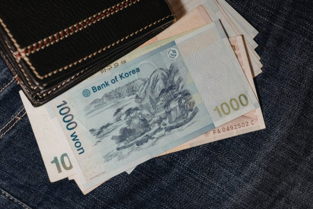 A close-up view of Korean banknotes and a wallet on a denim background.