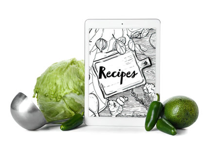 Fresh lettuce, lime, jalapenos, and a smartphone showing recipes, healthy cooking scene
