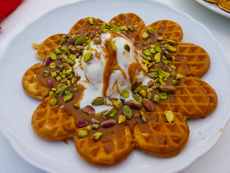 Delicious greek waffle with caramel, pistachio nuts and ice creamの写真素材