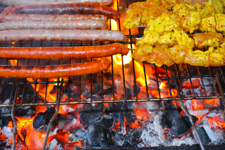 Delicious grilled chicken and sausage on barbecueの写真素材