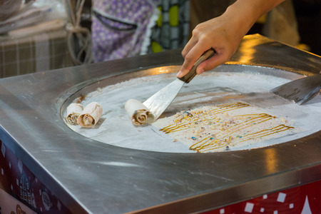 Thai woman cooking fresh handmade ice rolls in night market. Koh Samui, Thailandの写真素材