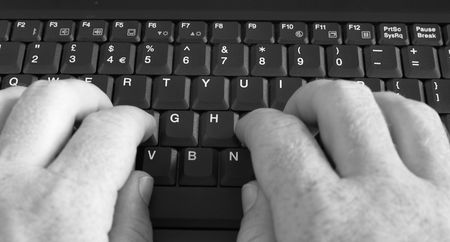 Close-up of businessman's hands typing on laptop's keyboard. Black and white image.の写真素材