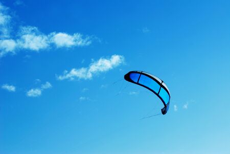 Big blue kite in the blue sky with some clouds の写真素材