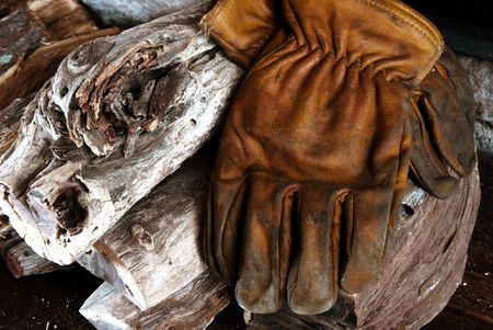 Leather gloves lying on a wood pileの写真素材