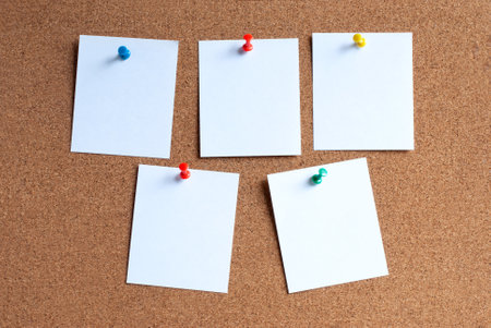 Notepaper with a pushpin on a corkboard.