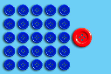 The different concept with a red button among many blue ones on a pastel blue background.