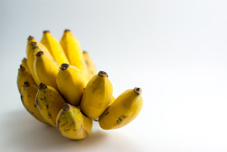 Bananas start to ripen and bruise on a white background.の写真素材